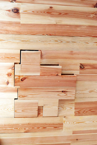 Close shot on interior wall detail. Little free-shaped secret storage space inside wall that opens on push. Knobless.