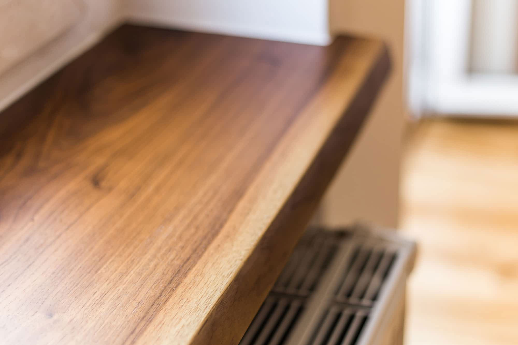 Bright wooden cabinet with dark wooden knobs and grain pattern. Close shot front.